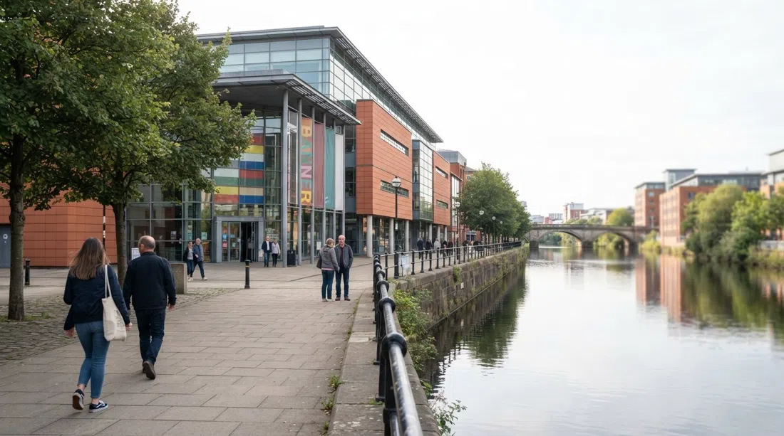 das People's History Museum an der Left Bank am Irwell, mit seiner Uferpromenade und dem von Bannern geprägten Eingang im sanften Tageslicht